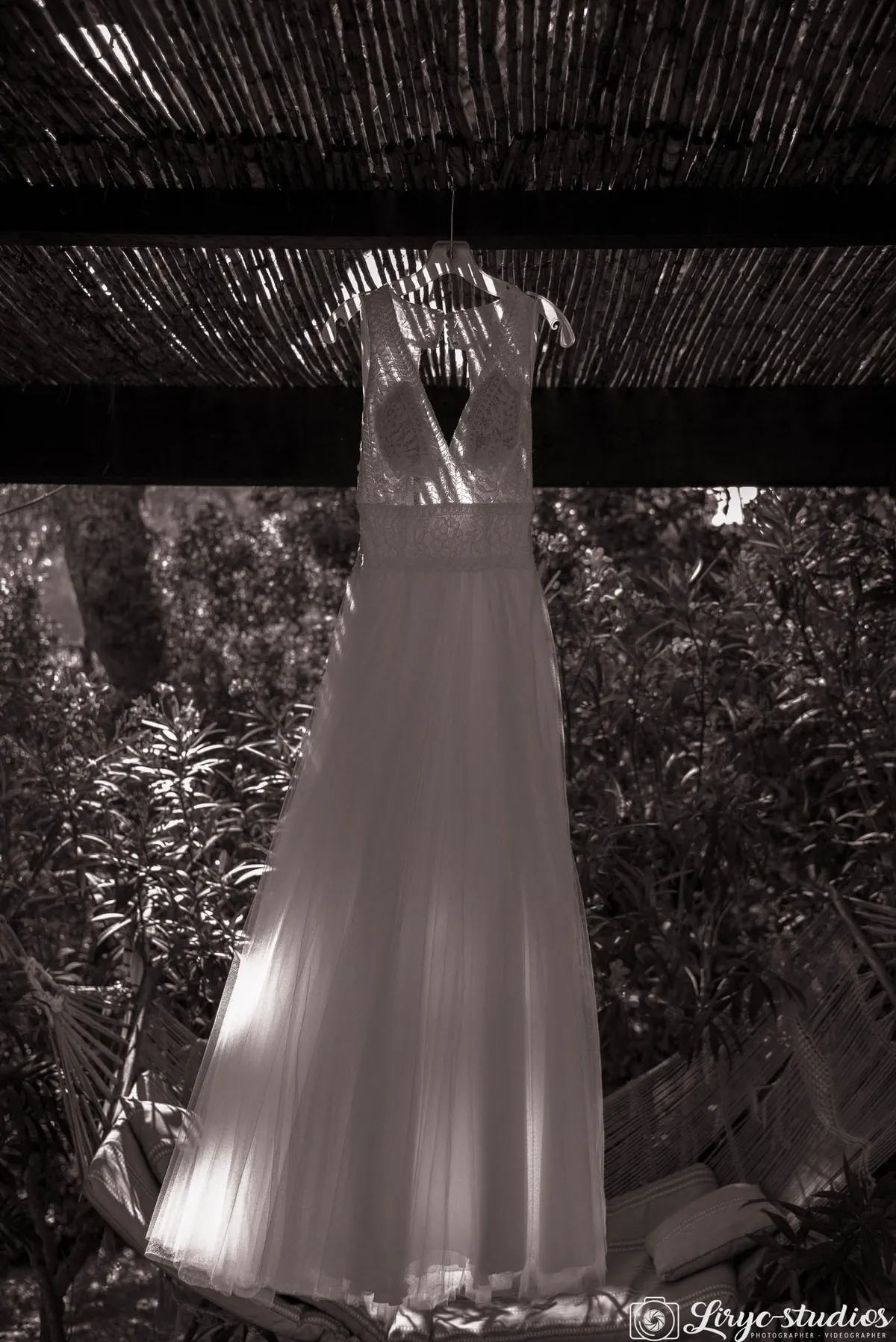 Robe de mariée suspendue sous une pergola, en noir et blanc