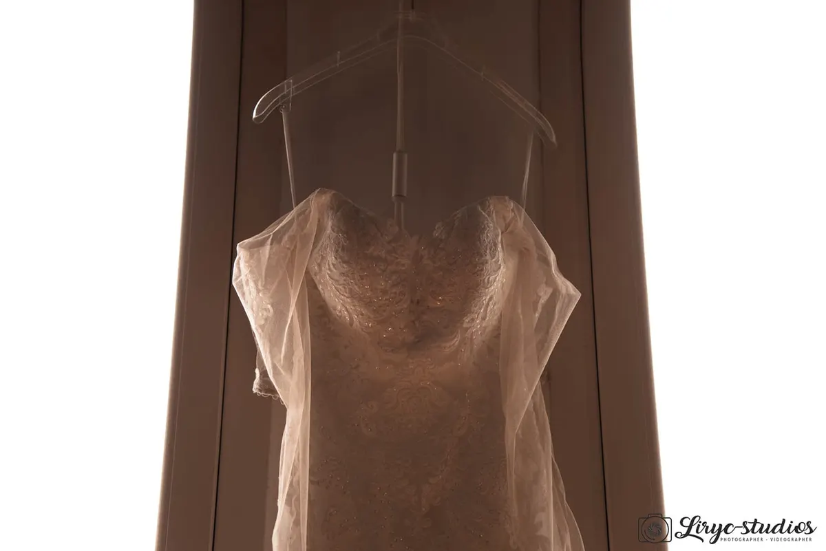 Robe de mariée en dentelle sur un cintre, en contre-jour