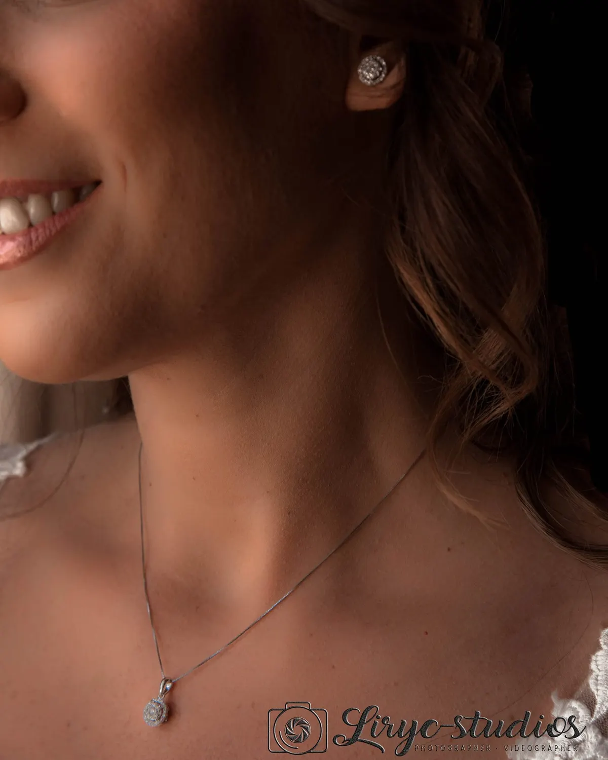 Sourire de la mariée et pendentif, en lumière douce
